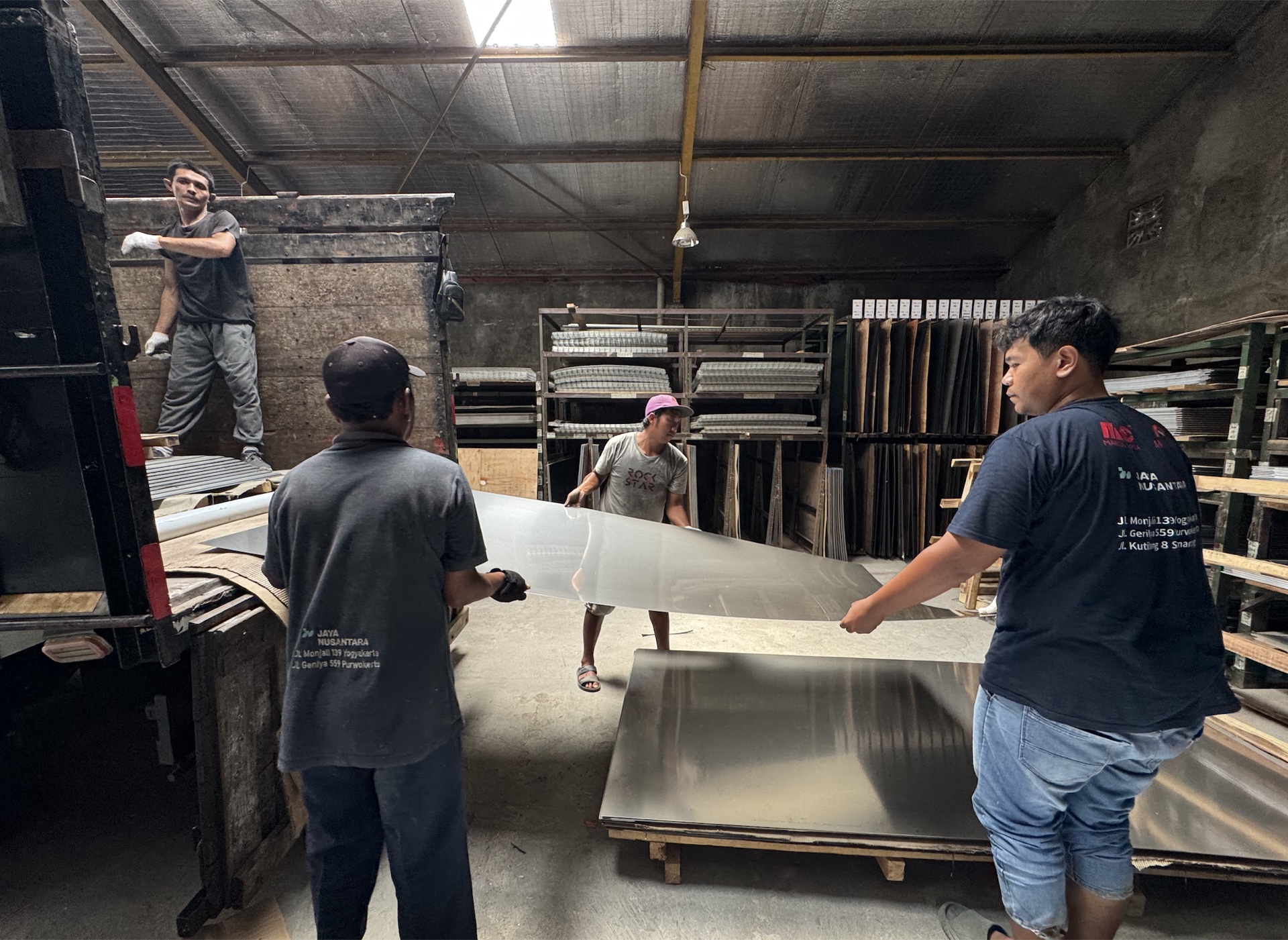 Tim Jaya Nusantara menangani lembaran material di area gudang